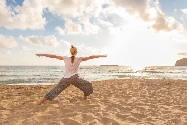 Mujer practicando yoga en la playa de mar al atardecer. —  Fotos de Stock