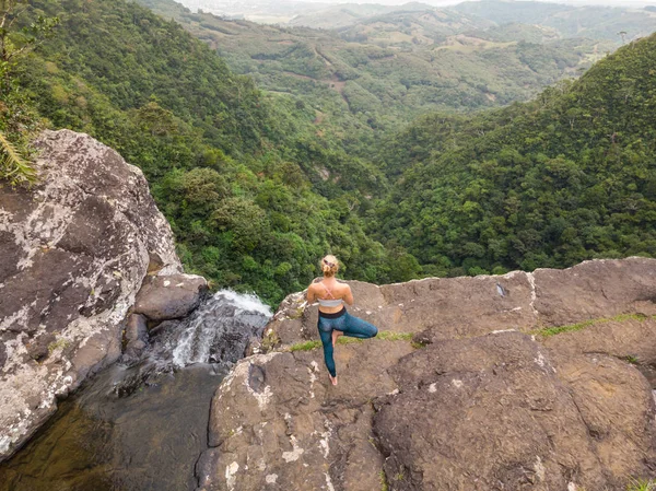 活跃运动的女人在大自然中放松，在毛里求斯热带天堂岛上的黑河峡谷国家公园用500英尺的瀑布练习瑜伽 — 图库照片