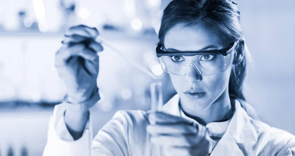 Jovem cientista pipetando em laboratório de ciências da vida. — Fotografia de Stock