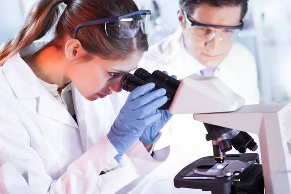 Jovens pesquisadores pesquisando em laboratório de ciências da vida. — Fotografia de Stock