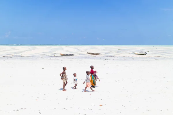Paje, Zanzíbar - 9 de febrero de 2015: Niños locales caminando en el pueblo de Paje foto perfecta playa blanca en marea baja el 9 de febrero de 2015 en Zanzíbar, Tanzania — Foto de Stock