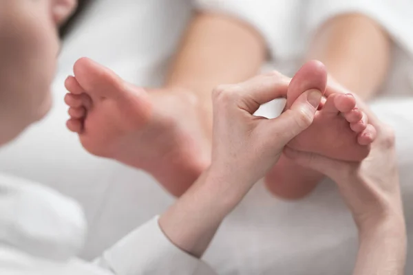 Professionell kvinnlig massör ger reflexologi massage till kvinnlig fot — Stockfoto