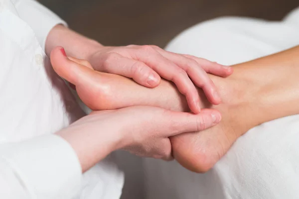 Profissional massagista feminino dando massagem reflexologia ao pé da mulher — Fotografia de Stock
