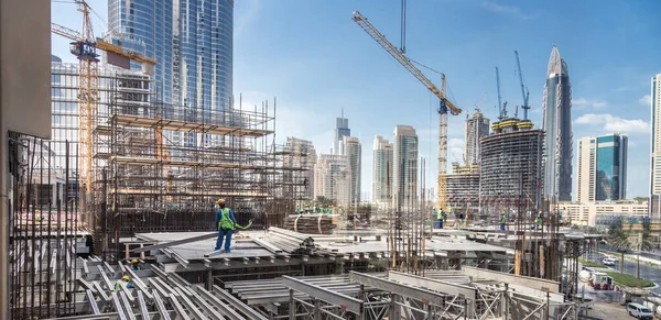 Os trabalhadores que trabalham no local de construção moderna trabalham em Dubai. Desenvolvimento urbano rápido consept — Fotografia de Stock