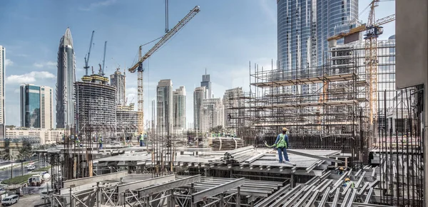 Los trabajadores que trabajan en el sitio de restricción moderna trabaja en Dubai. Consepto de desarrollo urbano rápido —  Fotos de Stock