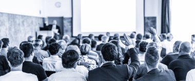Benim bir sorum var. Bir grup iş adamı konferans salonunda oturuyor. İş adamı kolunu kaldırıyor. Konferans ve Sunum. İş ve Girişimcilik