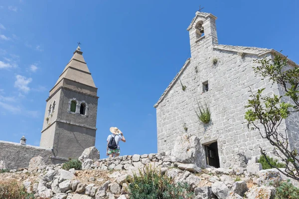 Female traveler sightseeing in an ancient costal village of Lubenice on the island of Cres, Croatia — Stock Photo, Image
