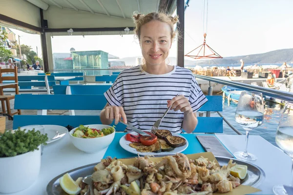 Hermosa turista femenina comiendo deliciosa comida de mar en vacaciones de verano en el tradicional restaurante costero croata junto al mar —  Fotos de Stock