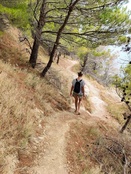 Joven activo feamle turista usando pequeña mochila caminando en co —  Fotos de Stock