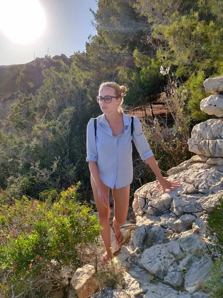 Молодой активный турист в маленьком рюкзаке ходит по прибрежной тропинке среди сосновых деревьев в поисках отдаленной бухты, чтобы спокойно поплавать на берегу моря в Хорватии. Путешествия и приключения — стоковое фото