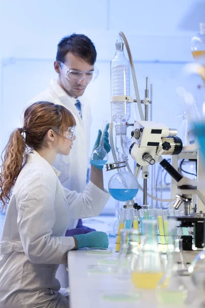 Jonge chemici die onderzoek doen in het laboratorium voor biowetenschappen. — Stockfoto