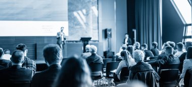 Sözcü, iş konferansında konferans salonunda konuşma yapacak. Mavi tonlu siyah beyaz resim