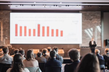 Sözcü, iş konferansında konferans salonunda konuşma yapacak. Konferans salonundaki tanınmayan insanların arka görüntüsü. İş ve girişimcilik kavramı