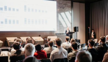 Kadın konuşmacı şirket iş konferansı hakkında bir konuşma yapıyor. Konferans salonundaki tanınmayan insanlar. İş ve Girişimcilik etkinliği