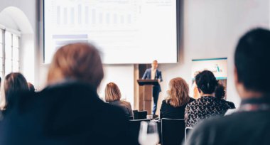 Sözcü, iş konferansında konferans salonunda konuşma yapacak. Konferans salonundaki tanınmayan insanların arka görüntüsü. İş ve girişimcilik kavramı