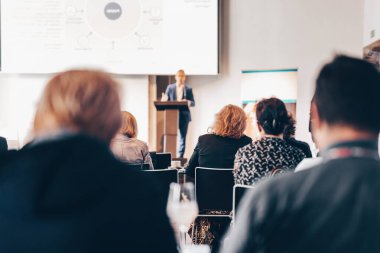 Sözcü, iş konferansında konferans salonunda konuşma yapacak. Konferans salonundaki tanınmayan insanların arka görüntüsü. İş ve girişimcilik kavramı