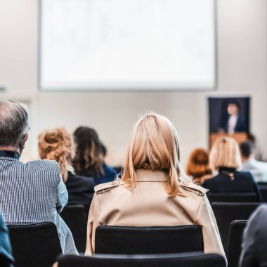 Sözcü, iş konferansında konferans salonunda konuşma yapacak. Konferans salonundaki tanınmayan insanların arka görüntüsü. İş ve girişimcilik kavramı