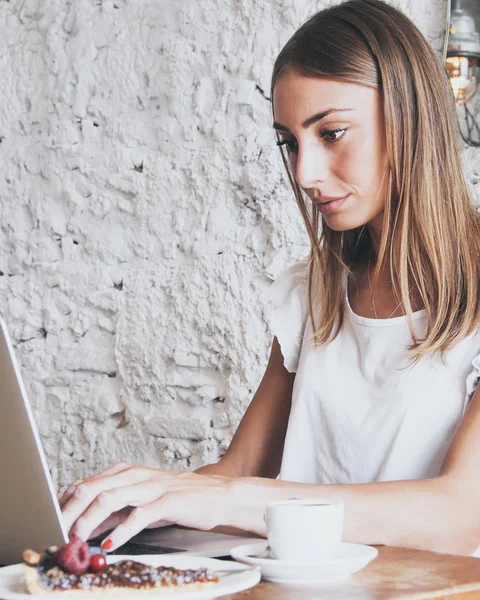 Freelance woman working with laptop in a coffee shop