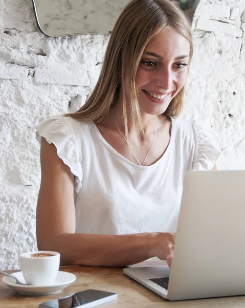 Freelance woman working with laptop in a coffee shop