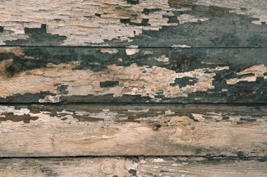 Eski boyanmış gri ahşap duvarın dokusu soyulmuş boya ve çatlaklarla kaplı.