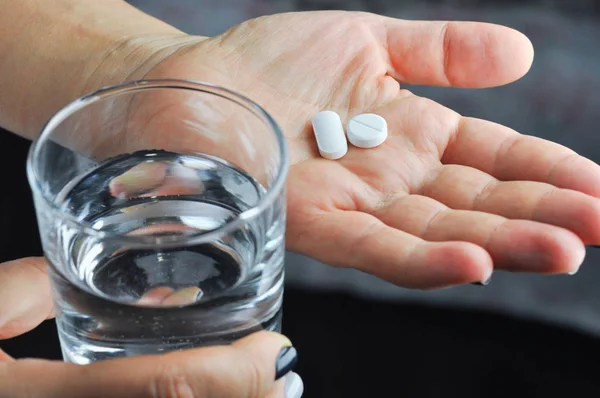 Ruce s tablety a sklenicí vody. — Stock fotografie
