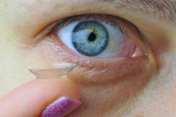 Woman eye with contact lens.