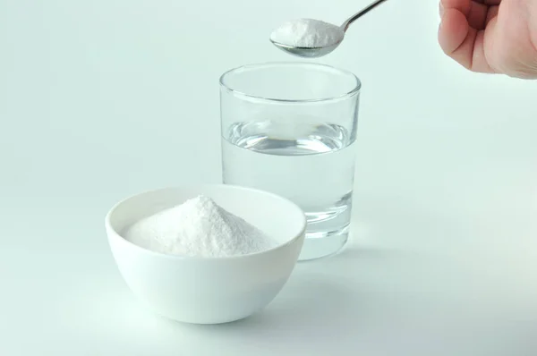 Baking soda, spoon and glass of water. — Stock Photo, Image
