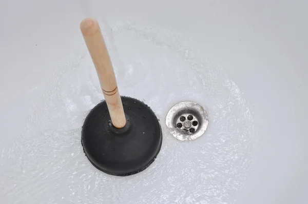 Plunger and clogged bath. Cleaning concept. Stock Photo