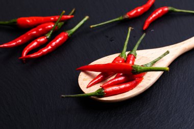 Tahta kaşık siyah arduvaz taş zemin üzerine kırmızı Tay chilies biber