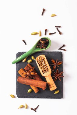 Egzotik bitkisel gıda kavramı karışımı organik baharat tarçın sopa, kakule bakla, Yıldız anason ve kişniş kopya ile siyah arduvaz taş plaka üzerinde