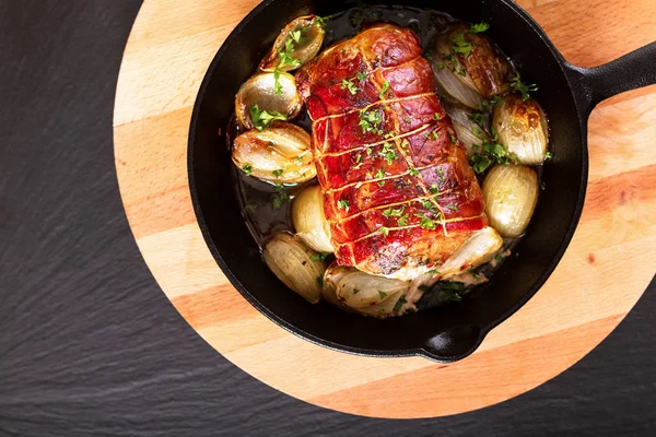 食品概念自制培根填充猪肉肌腱在铁铸造平底锅在圆形木板烤 — 图库照片