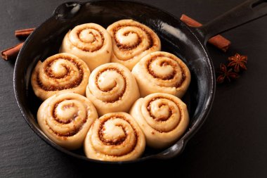 Kopya alanı ile tava dökme demir tavada gıda kavramı kabarık hamur ev yapımı tarçın rulo fırında önce yükseltilmiş