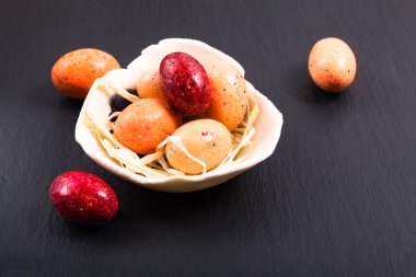 Tatil gıda kavramı renkli şeker ve çikolata Paskalya yumurtaları kopya alanı ile siyah arduvaz plaka üzerinde