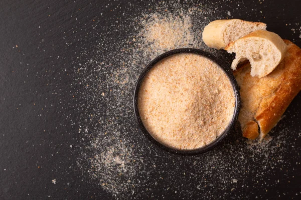 Ingredientes alimentares migalhas de pão orgânico caseiro em cerâmica preta — Fotografia de Stock