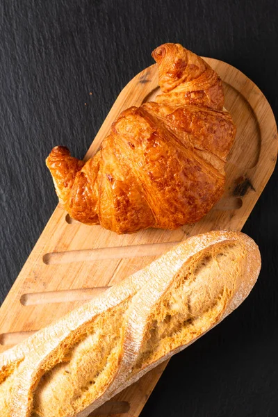 Food concept French croissant on black slate board with copy spa