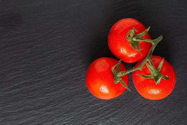 Concetto di cibo pomodori biologici su lavagna nera con copy spa — Foto Stock