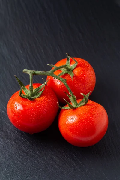 Conceito de comida tomates orgânicos em placa de ardósia preta com spa cópia — Fotografia de Stock