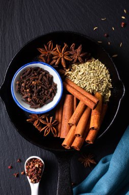 Çin Baharat Yıldızı Anason, Fennel Tohumları, Szechuan Peppercorn, Tam Karanfil ve Tarçın Yapıştırıcısı kökenli siyah kırsal arka planda fotokopi alanı