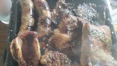 Barbekü ızgarasında Izgara biftek manzarası. Tavuk, sosis ve biftek dumanlı. Yakın çekim görünüm.