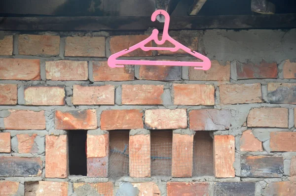 Roze Hangers Tegen Bakstenen Muur — Stockfoto