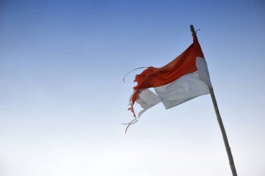 Mavi gökyüzü karşı eski ve yırtık sökük Endonezya'nın bayrak