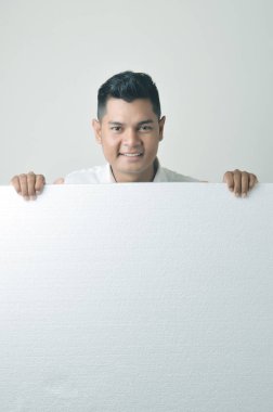 Asyalı erkek boş bir beyaz tahta holding