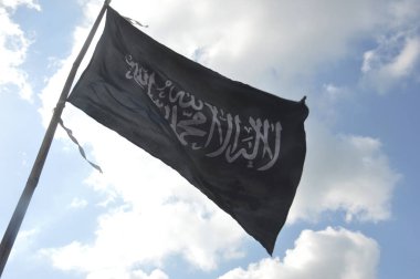 Siyah tauhid bayrağı mavi gökyüzü ve beyaz bulutlar