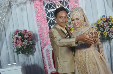 TARAKAN - Indonezya, 5 Nisan 2018: Endonezyalı gelin çiftler kahverengi kebaya kostümü giymişlerdi