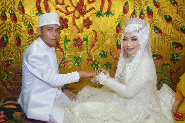 TARAKAN - Indonezya, 6 ARALIK 2018: Endonezyalı gelin yüzüğü damadın parmaklarına takıyor