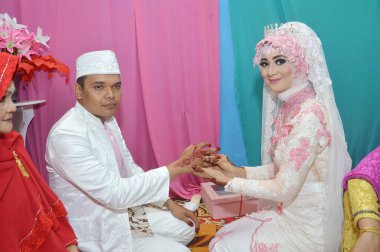 TARAKAN - INDONEZYA, 4 Mart 2017: Endonezyalı gelin yüzüğü damadın parmaklarına takıyor