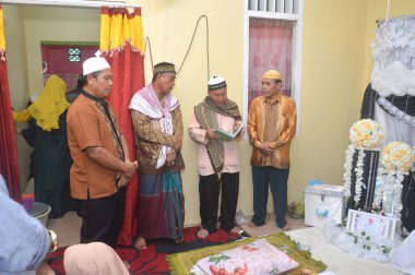TARAKAN, INDONEZYA - 17 Ekim 2019: Müslüman bebekler veya İslam 'da ilk saç kesiminde bir rahip dua okudu. Aqiqah töreni genellikle bebek doğduktan yedi gün sonra yapılır.