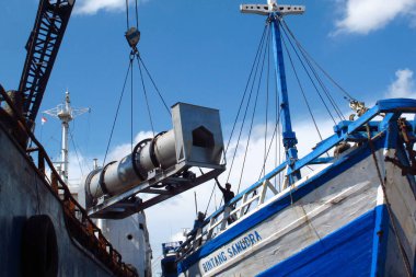 SURABAYA - INDONEZYA, 23 Haziran 2013: Kalimas Surabaya limanındaki fenisi gemilerinden mal yükleme ve boşaltma faaliyetleri