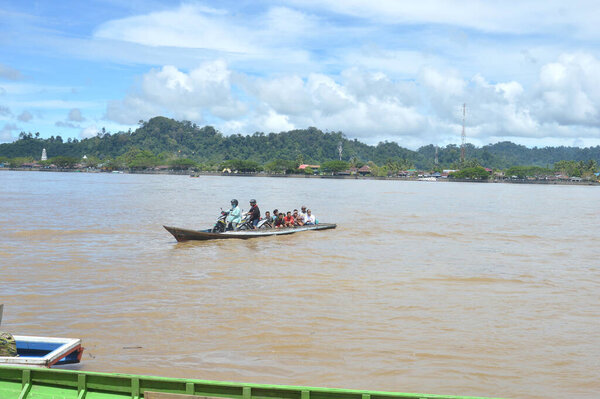 TANJUNG SELOR - INDONESIA, 19 JANUARY 2019 :  wooden boats load passengers and motorbikes from the village of Tanjung Palas to Tanjung Selor or vice versa across the Kayan River