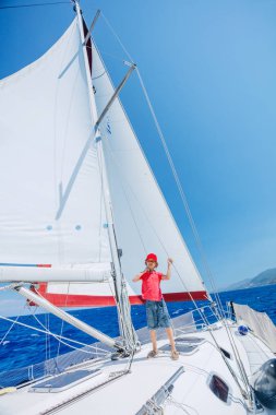 Küçük çocuk yaz gezisinde yelkenli yatında. Seyahat macerası, çocuğuyla yat gezisi..